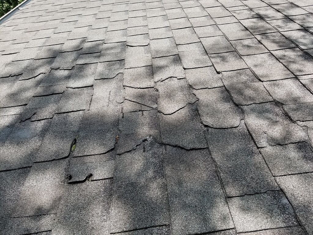 Toiture présentant des tuiles déplacées et de la mousse